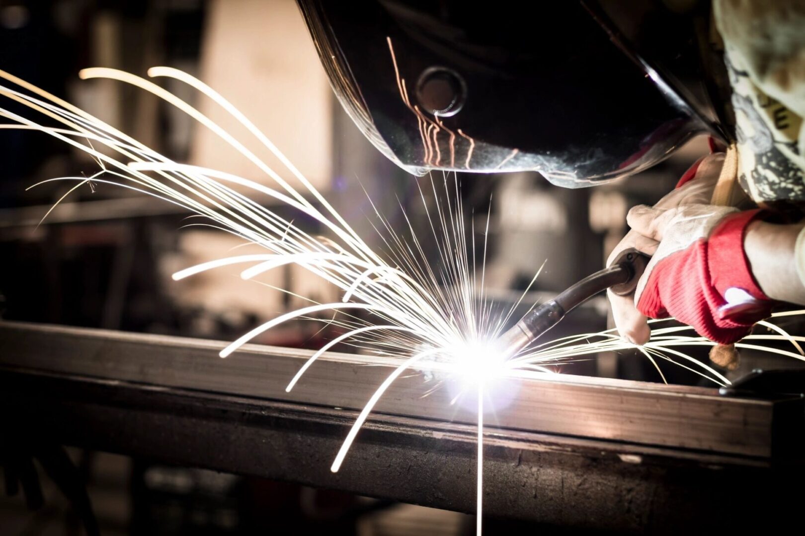 A person welding metal with sparks flying from the side.